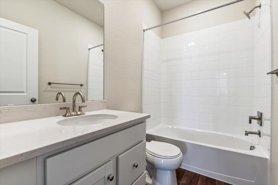 A bathroom with a tub sink and toilet.