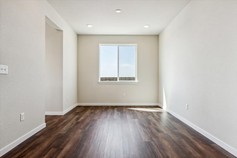 A room with a wood floor and a window.