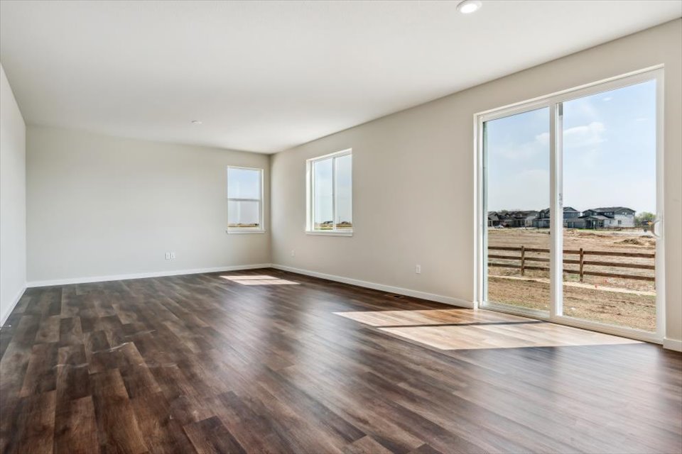 A room with a wood floor and windows.