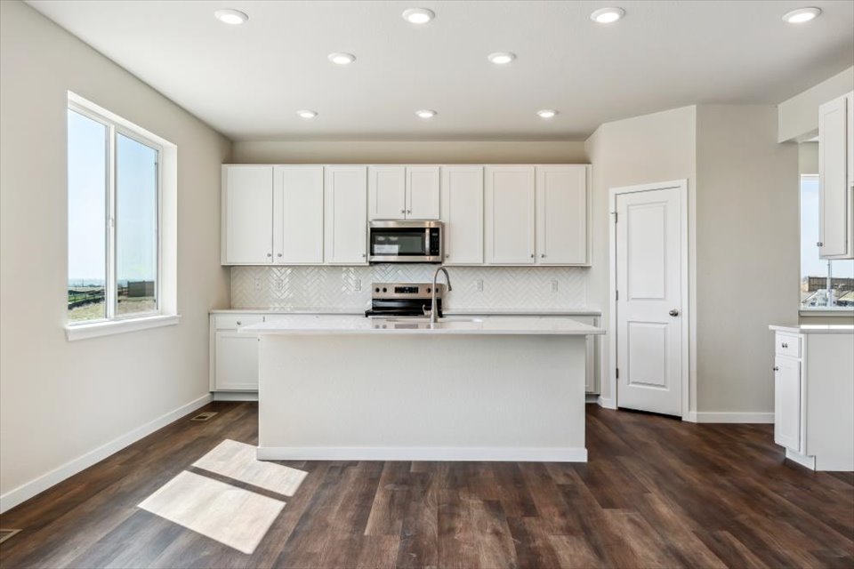 A kitchen with white cabinets.