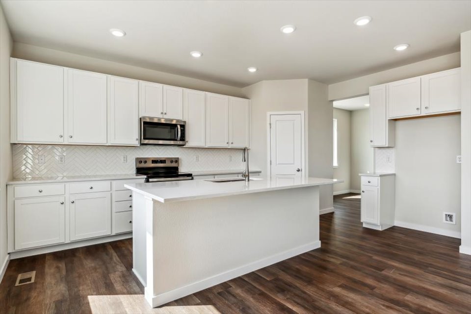 A kitchen with white cabinets.