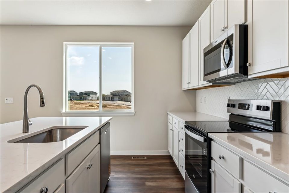 A kitchen with white cabinets.