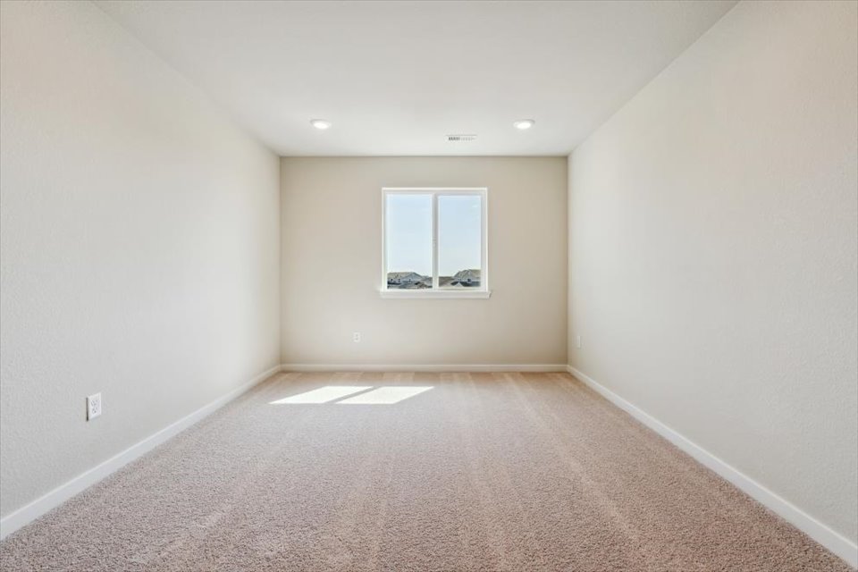A room with a window and carpet.