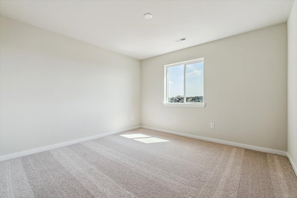 A room with a window and a carpet.