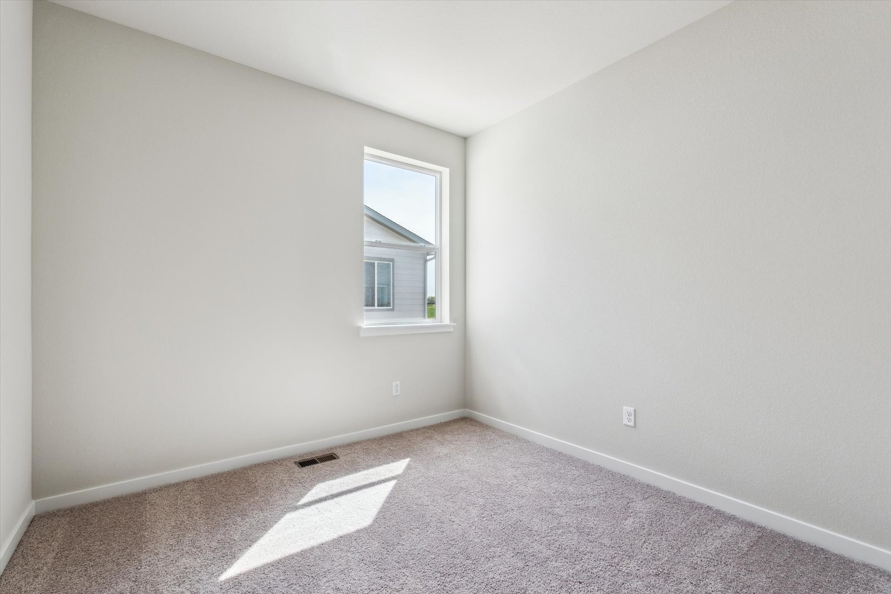 A room with a window and carpet.