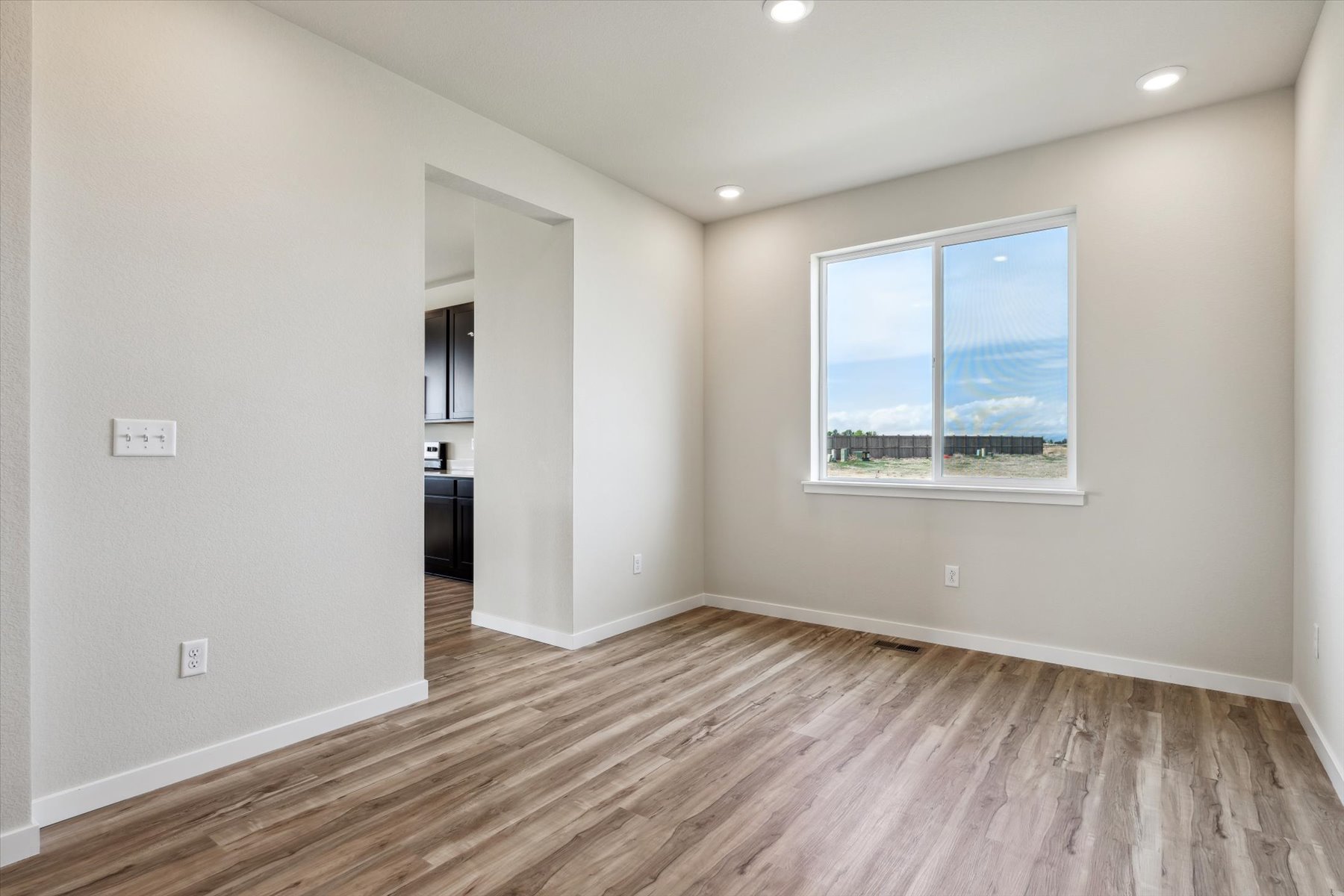 A room with a wood floor and a window.
