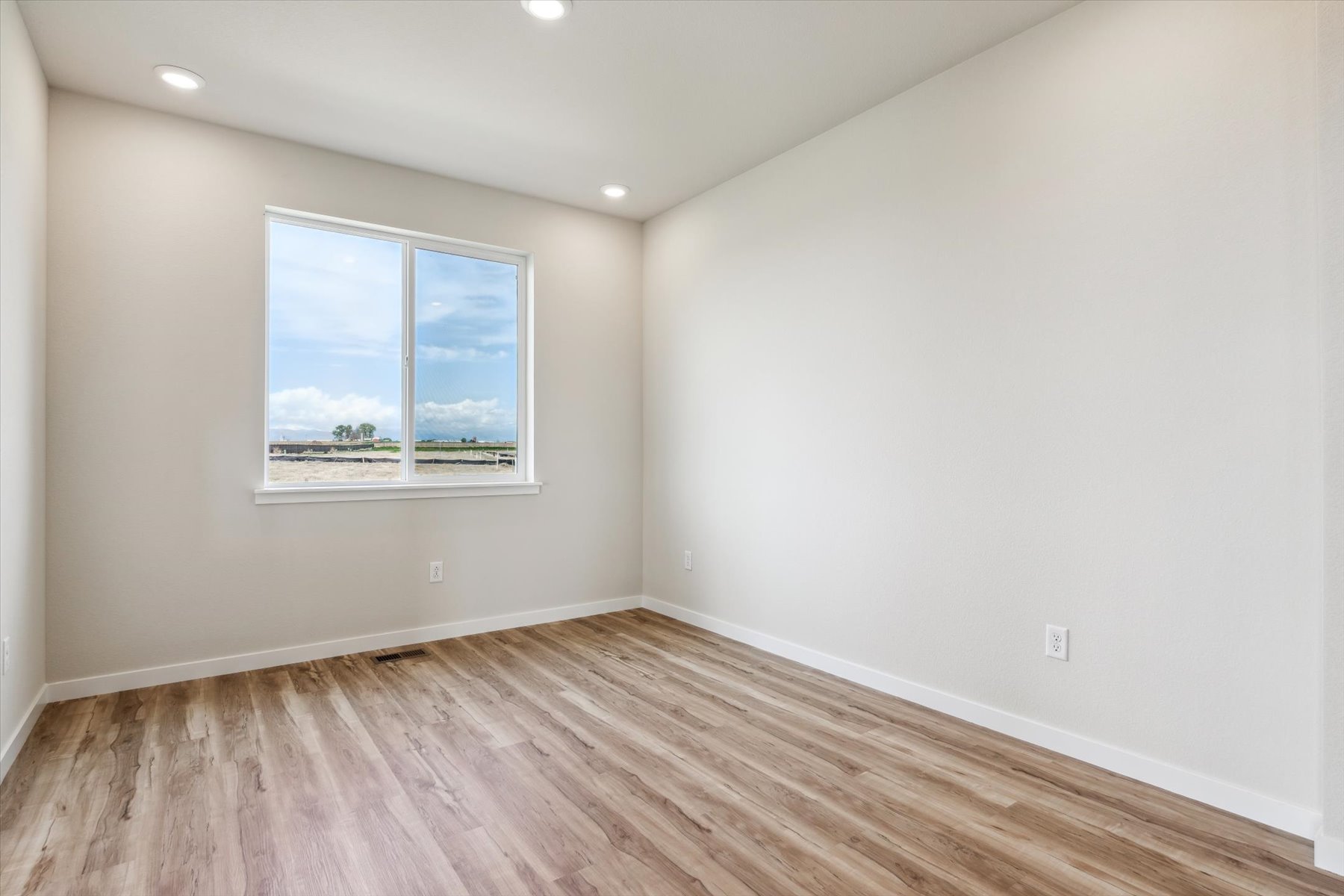 A room with a wood floor and a window.