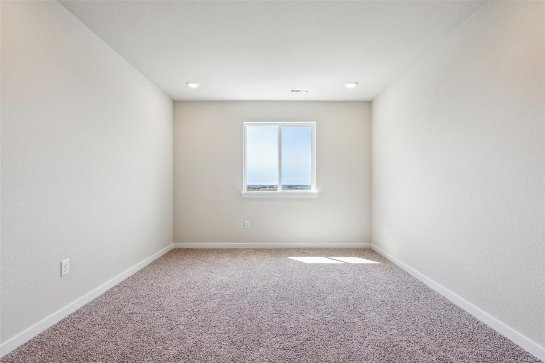 A room with a window and carpet.