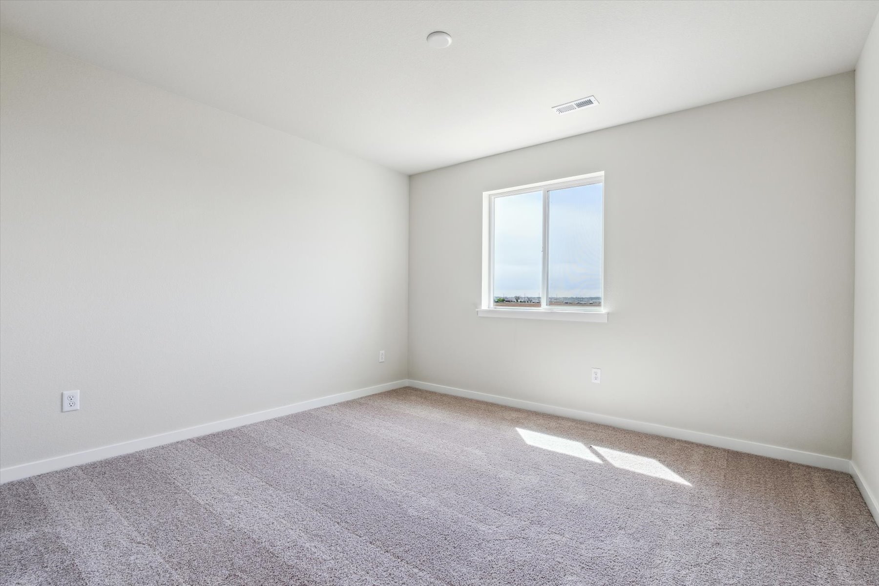 A room with a window and carpet.