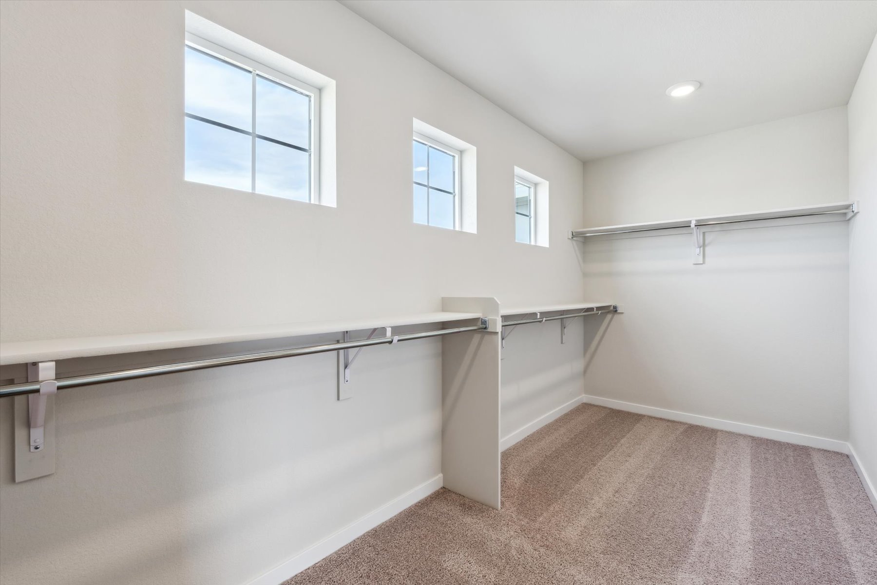A room with a metal railing and windows.