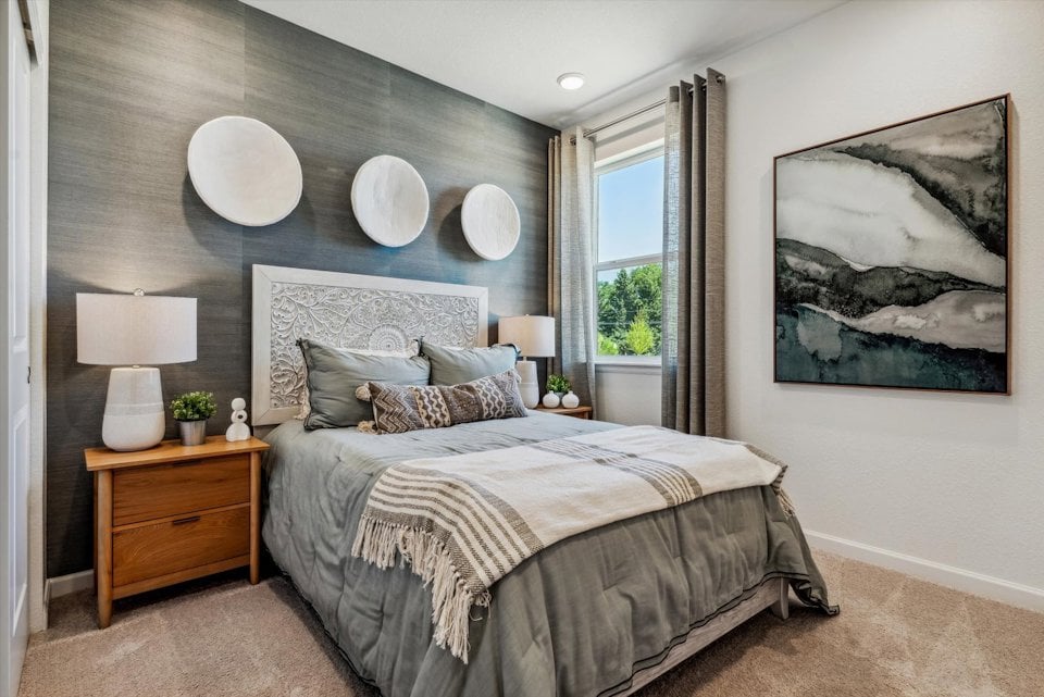 A bedroom with a bed and lamps.