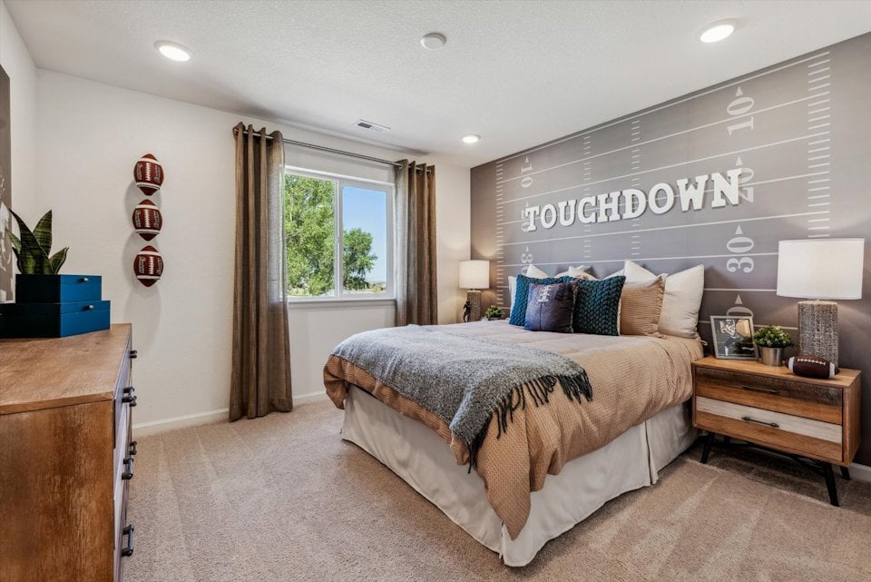 A bedroom with a bed and a desk.