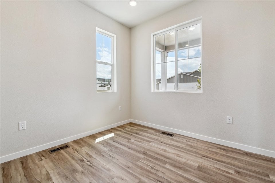 A room with a wood floor and windows.