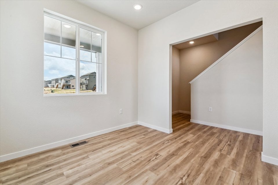 A room with a window and a wood floor.