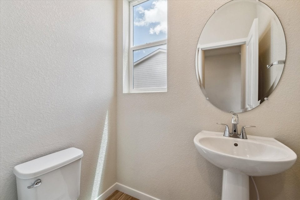 A bathroom with a round mirror.