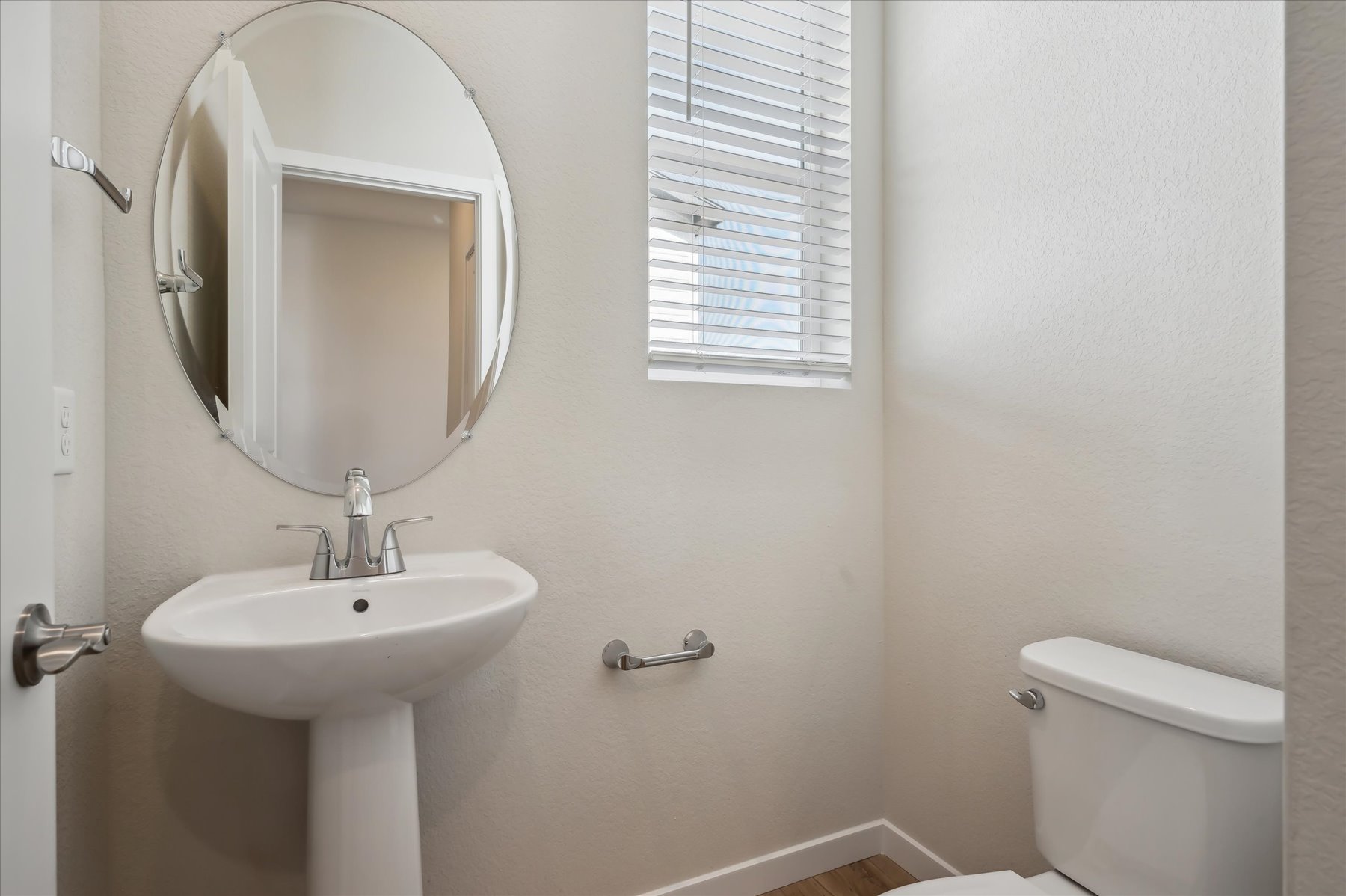 A bathroom with a round mirror.