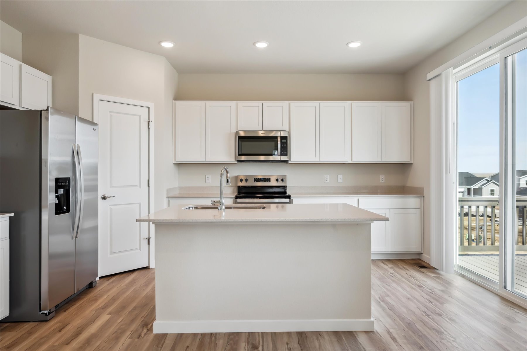 A kitchen with white cabinets.