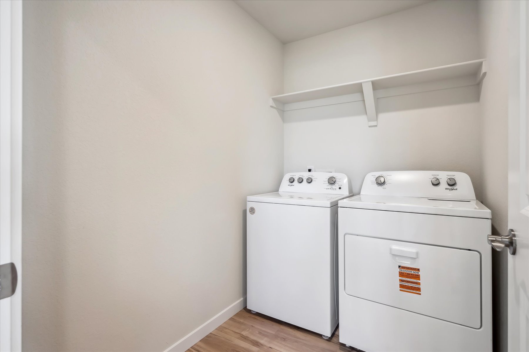 A white laundry room with a washer and dryer.