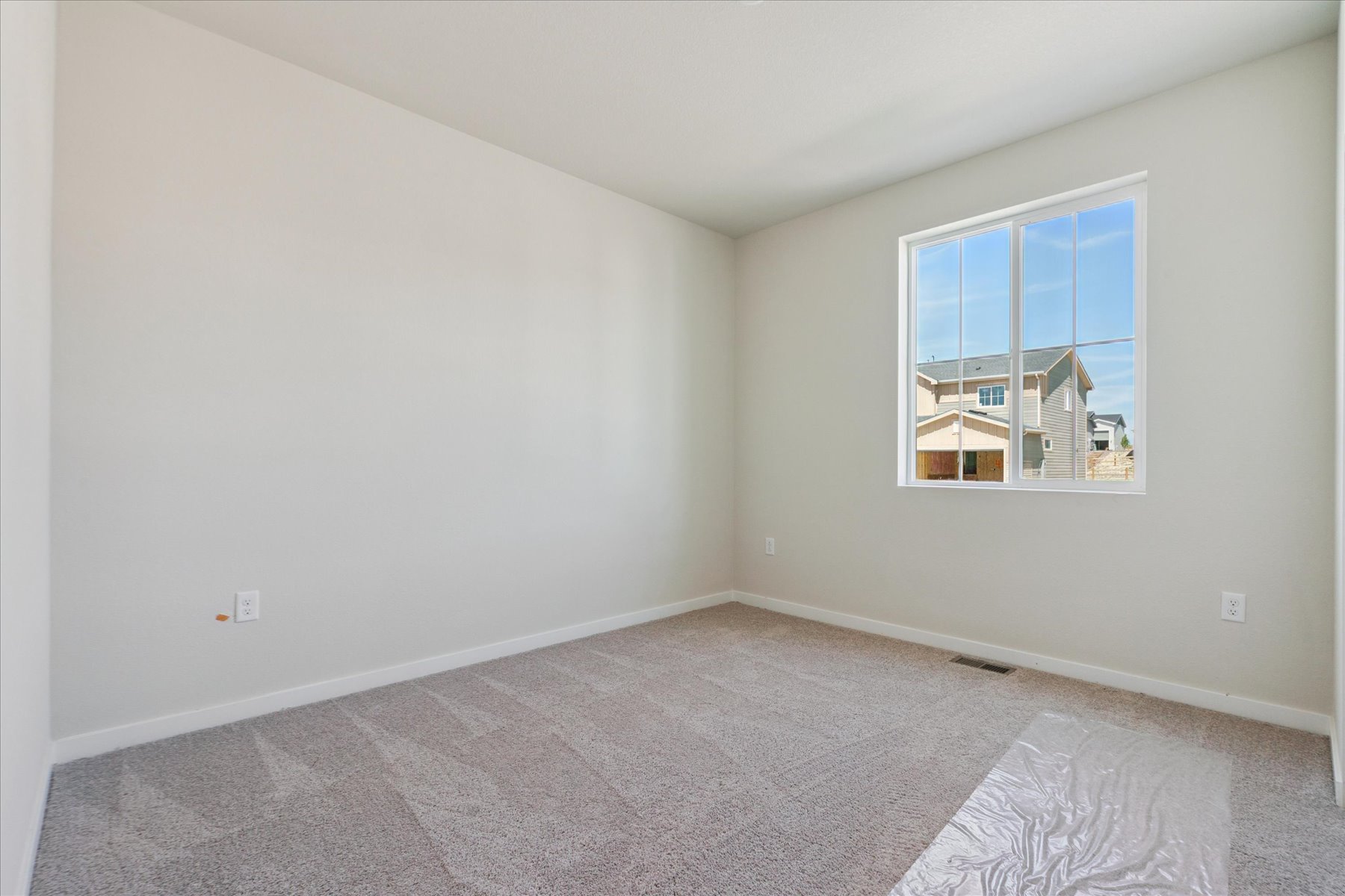 A room with a carpet and a window.