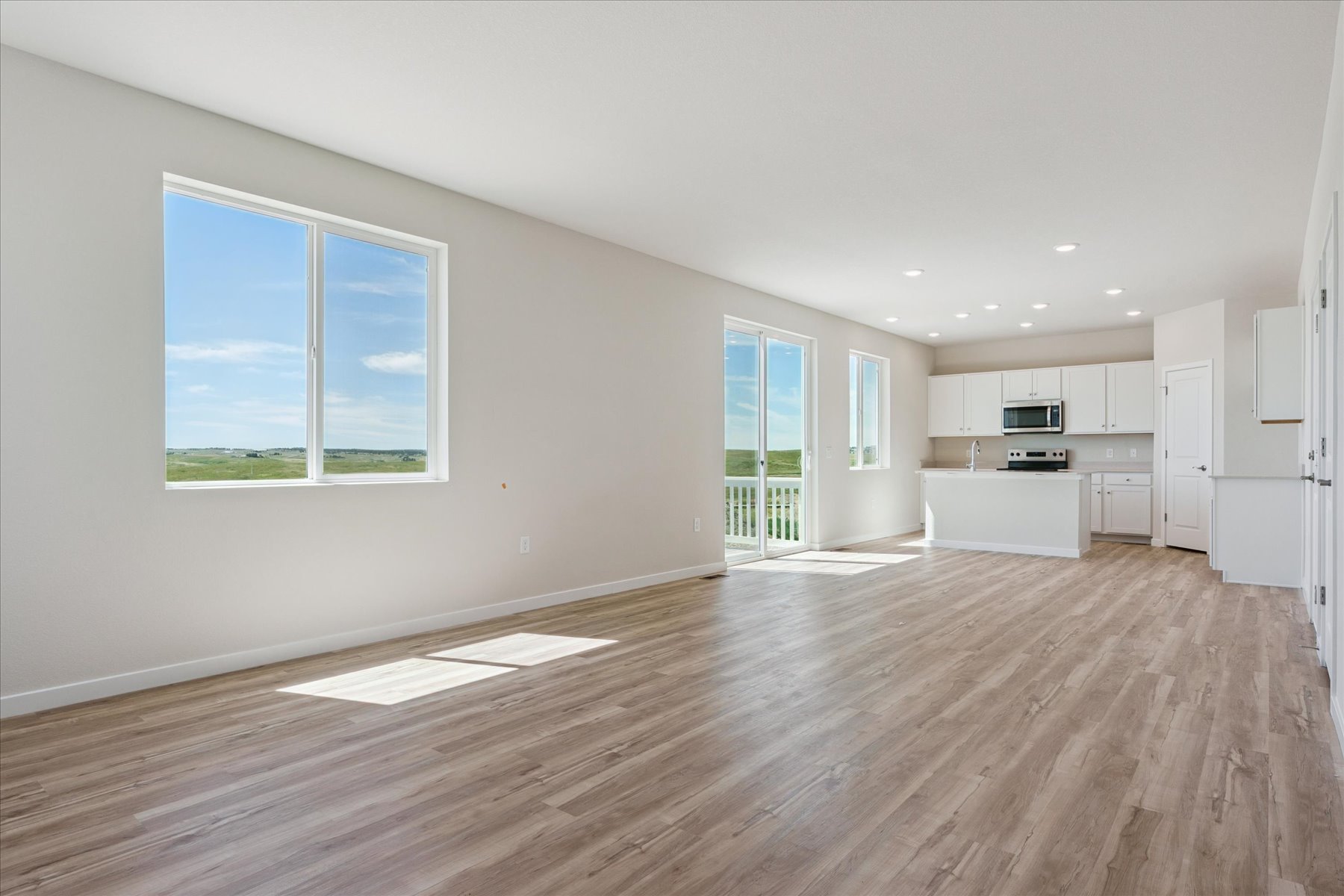 A large empty room with a wood floor and a large window.