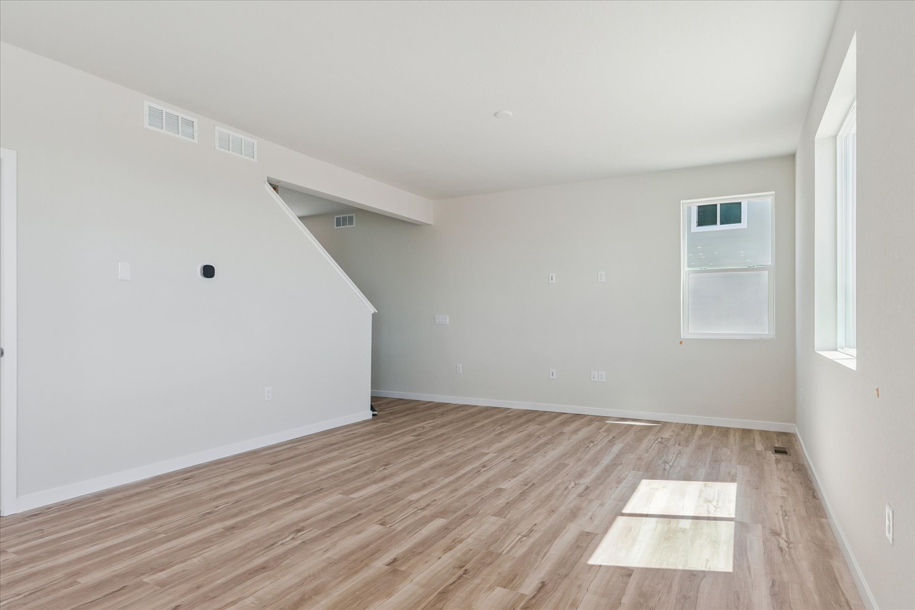 A room with a wood floor and white walls.