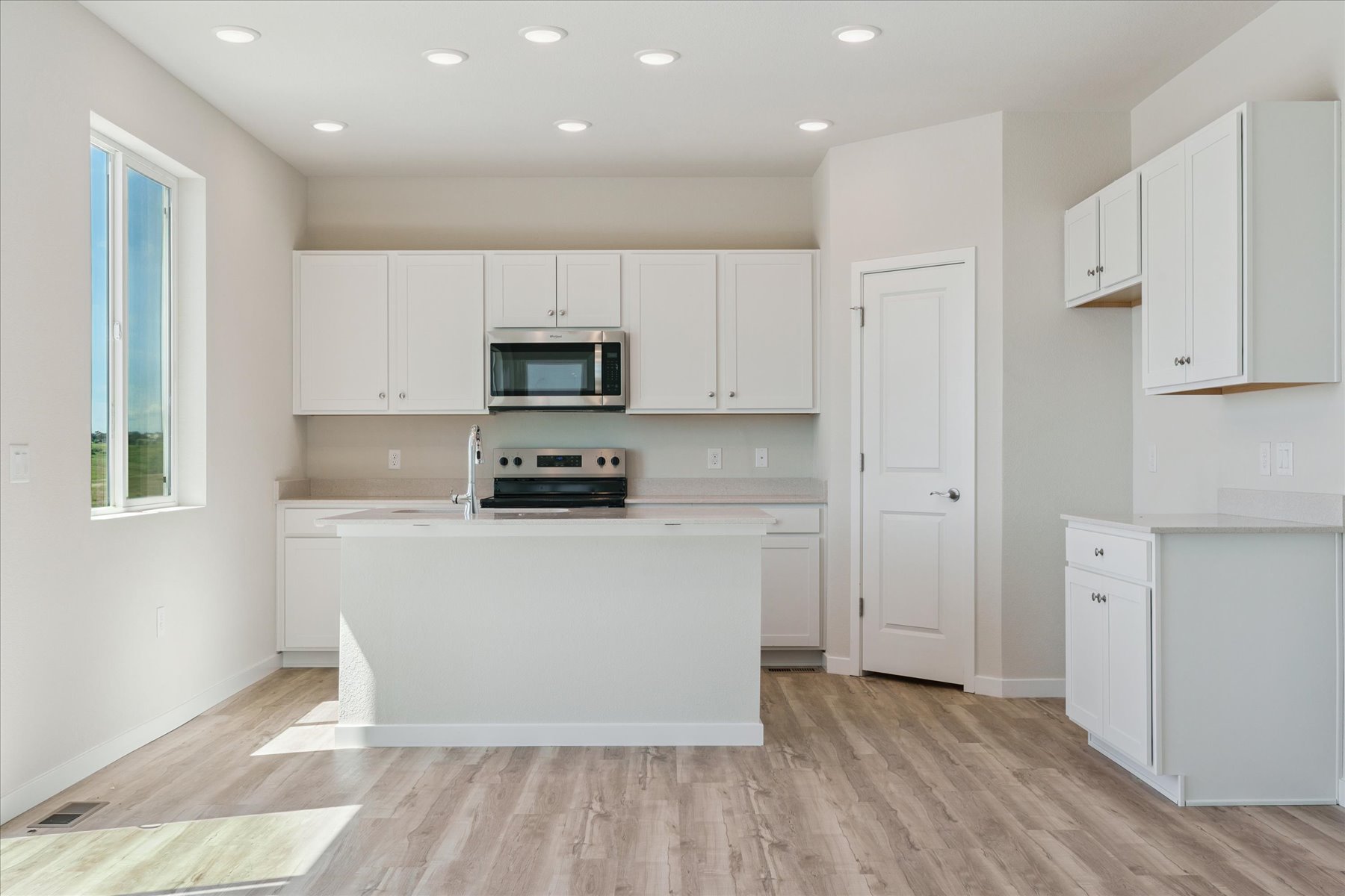 A kitchen with white cabinets.