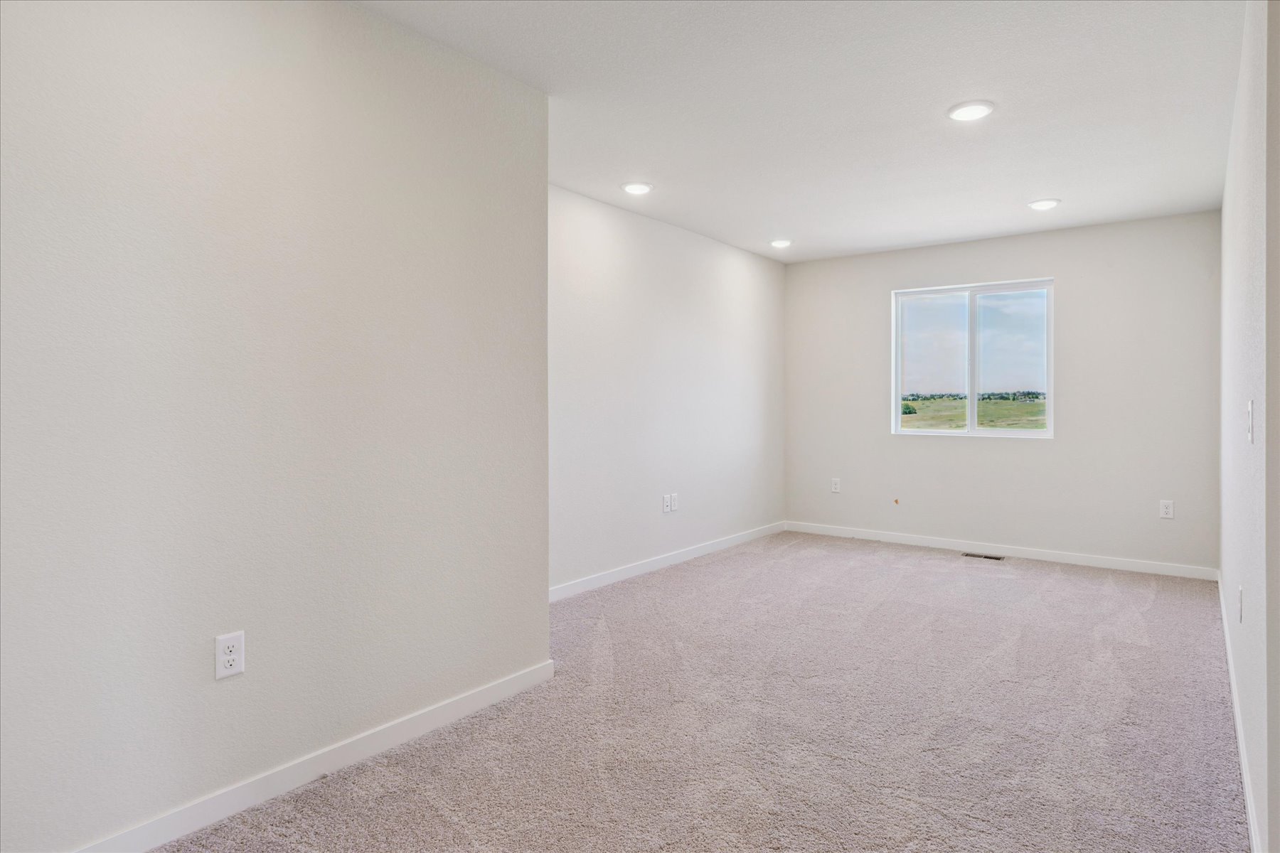 A room with a carpet and a window.