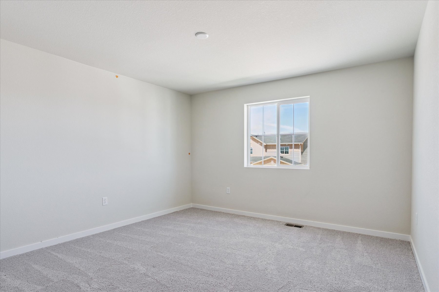 A room with a window and a carpet.