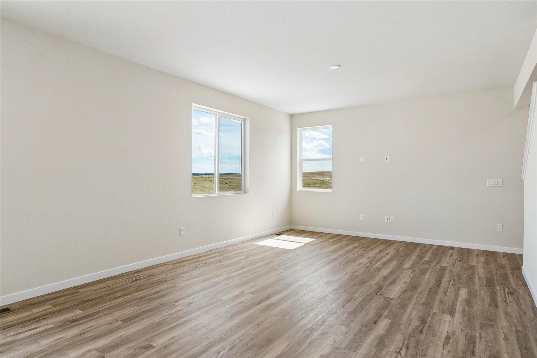 A room with a wood floor and windows.