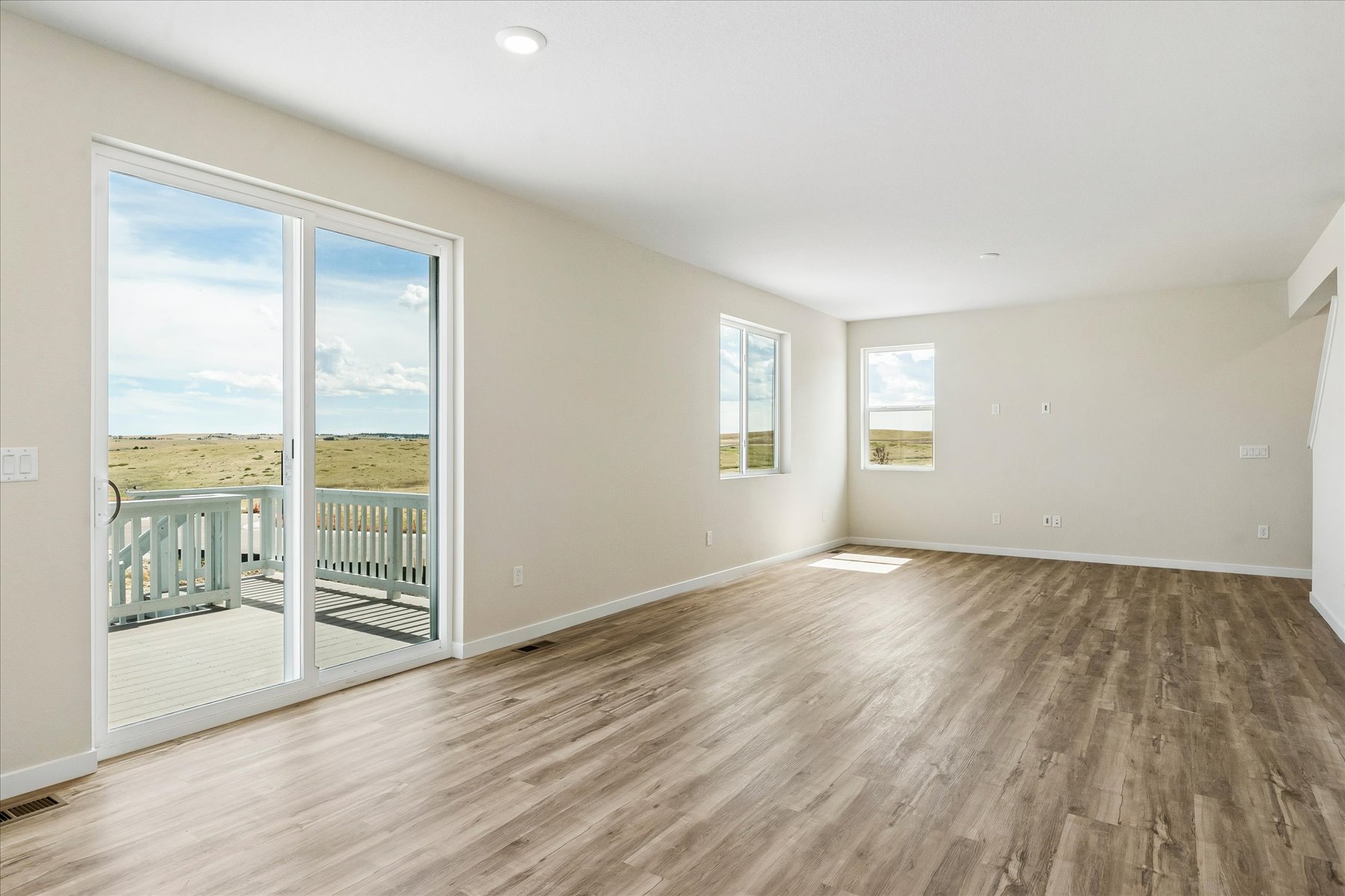 A room with a wood floor and a large window.