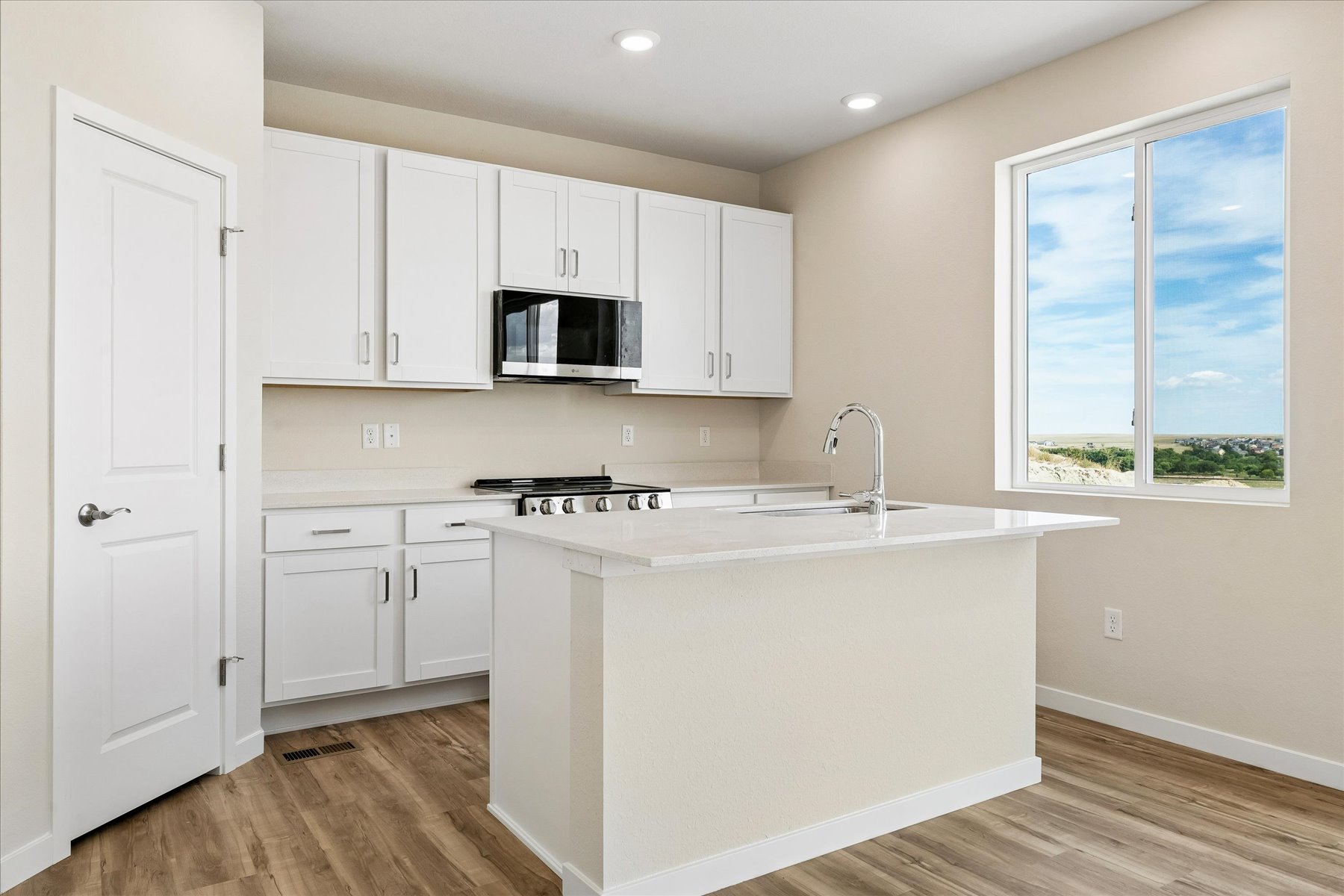 A kitchen with white cabinets.