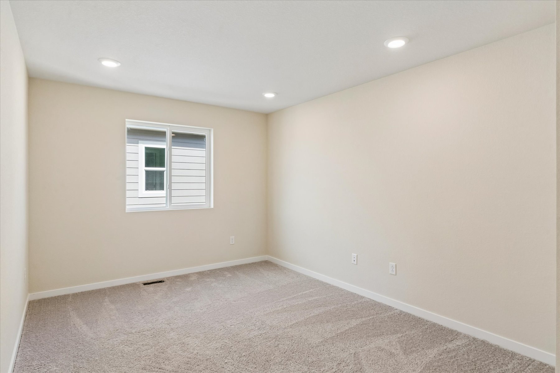 A room with a window and a carpet.