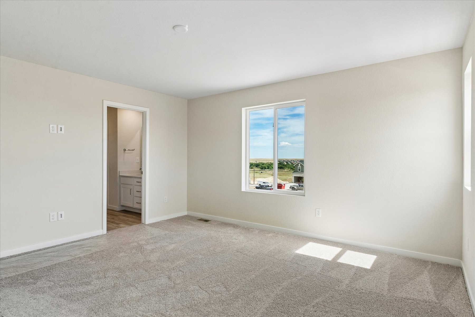 A room with a window and a carpet.