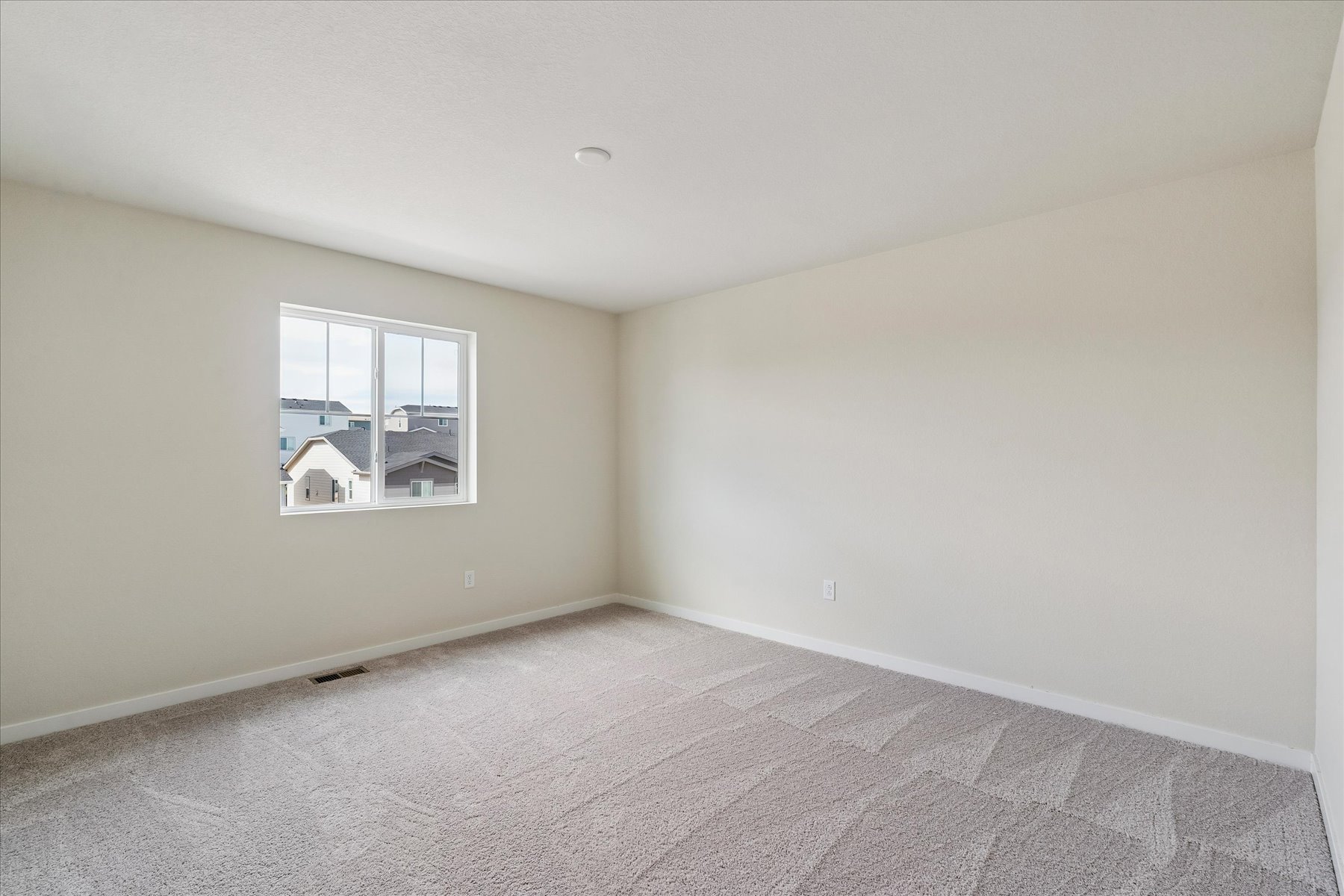 A room with a window and a carpet.