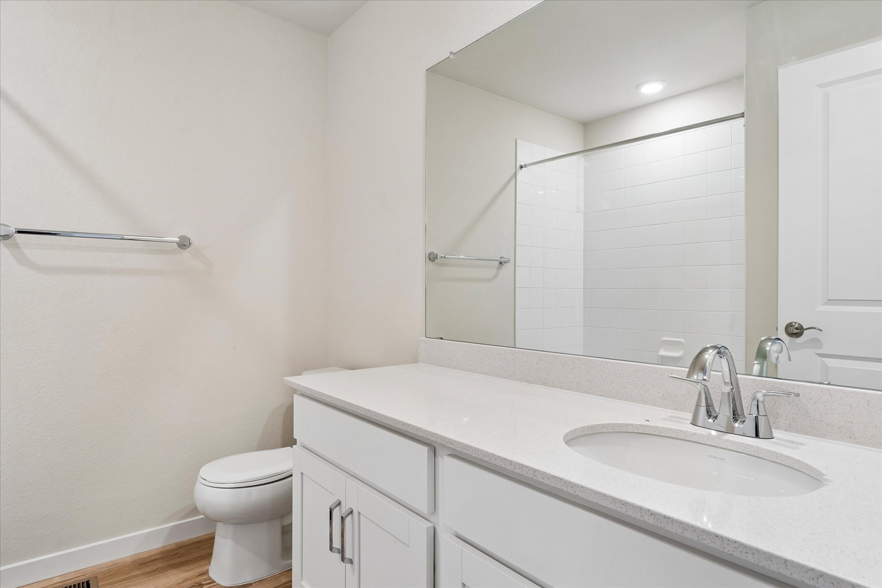 A bathroom with a large mirror.