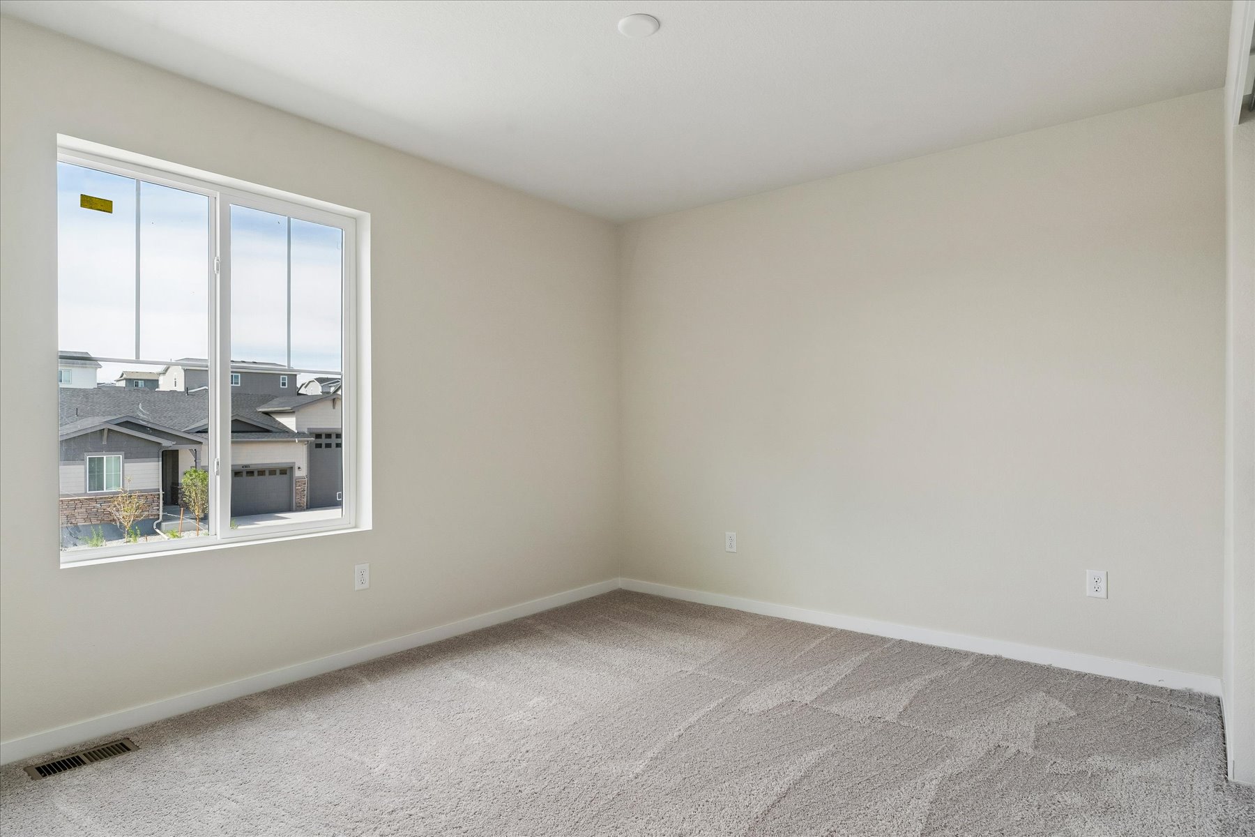 A room with a window and a carpet.