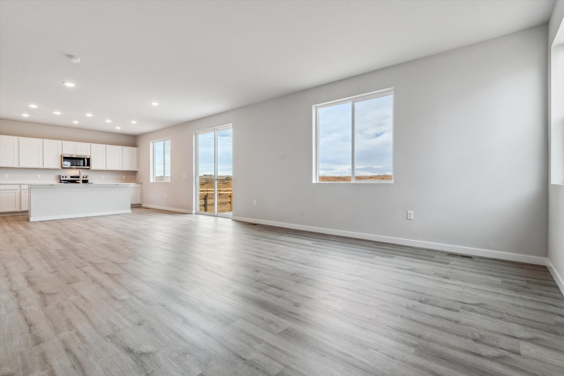 A large empty room with a wood floor and white walls.