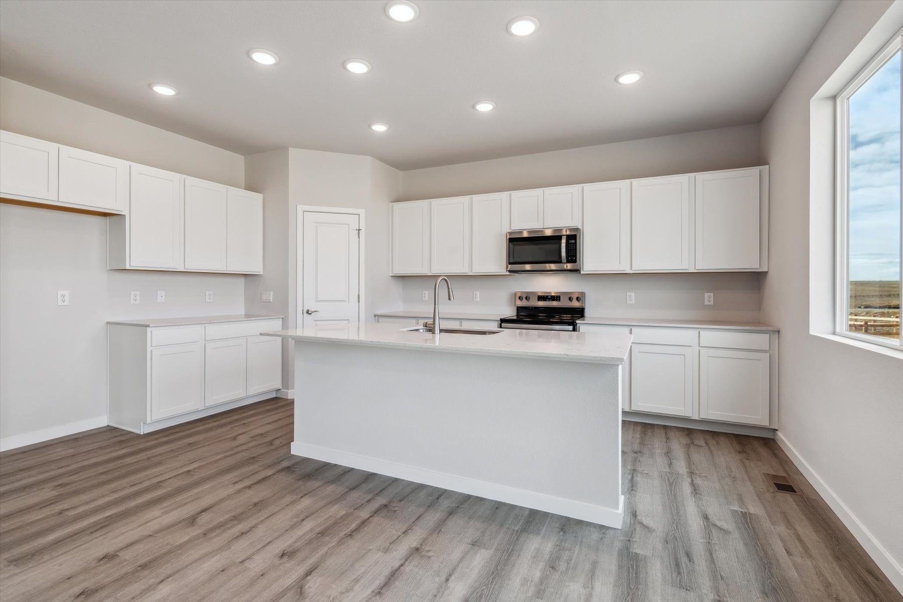 A kitchen with white cabinets.