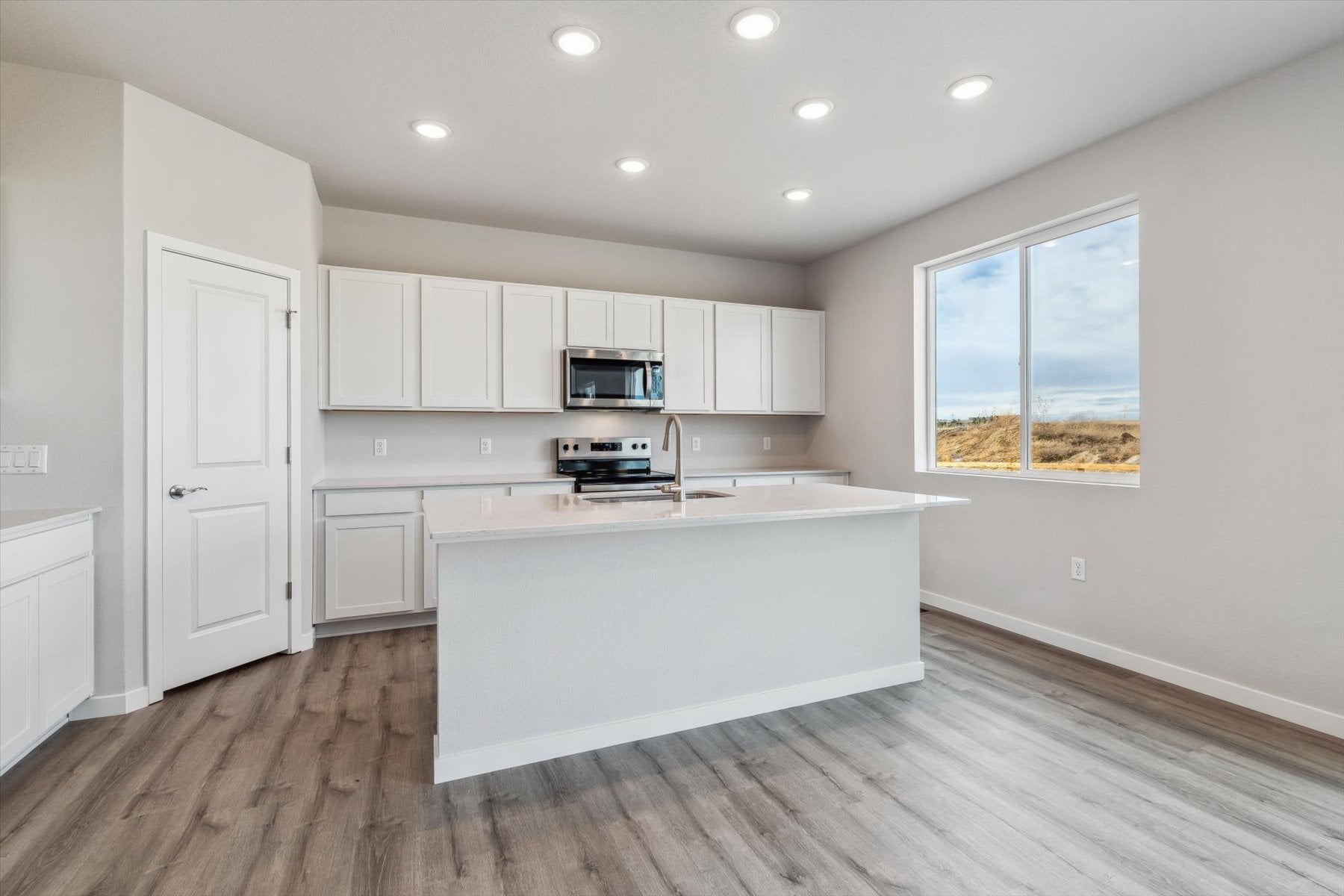 A kitchen with white cabinets.