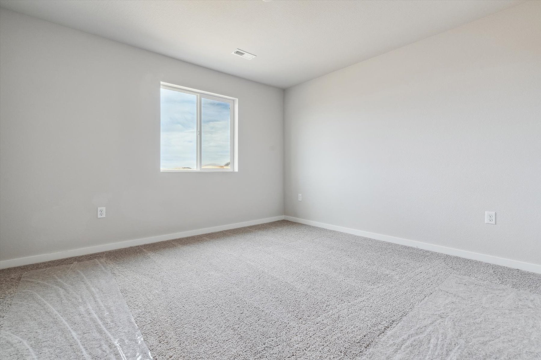 A room with a window and carpet.