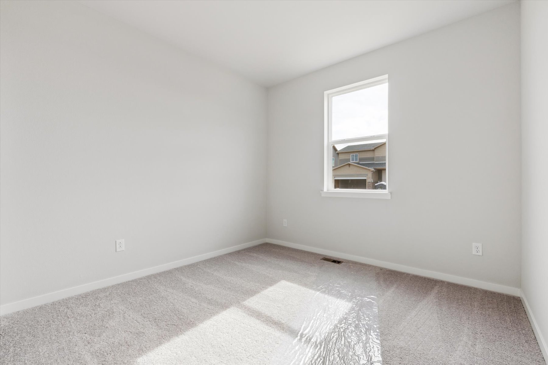 A room with a rug and a window.