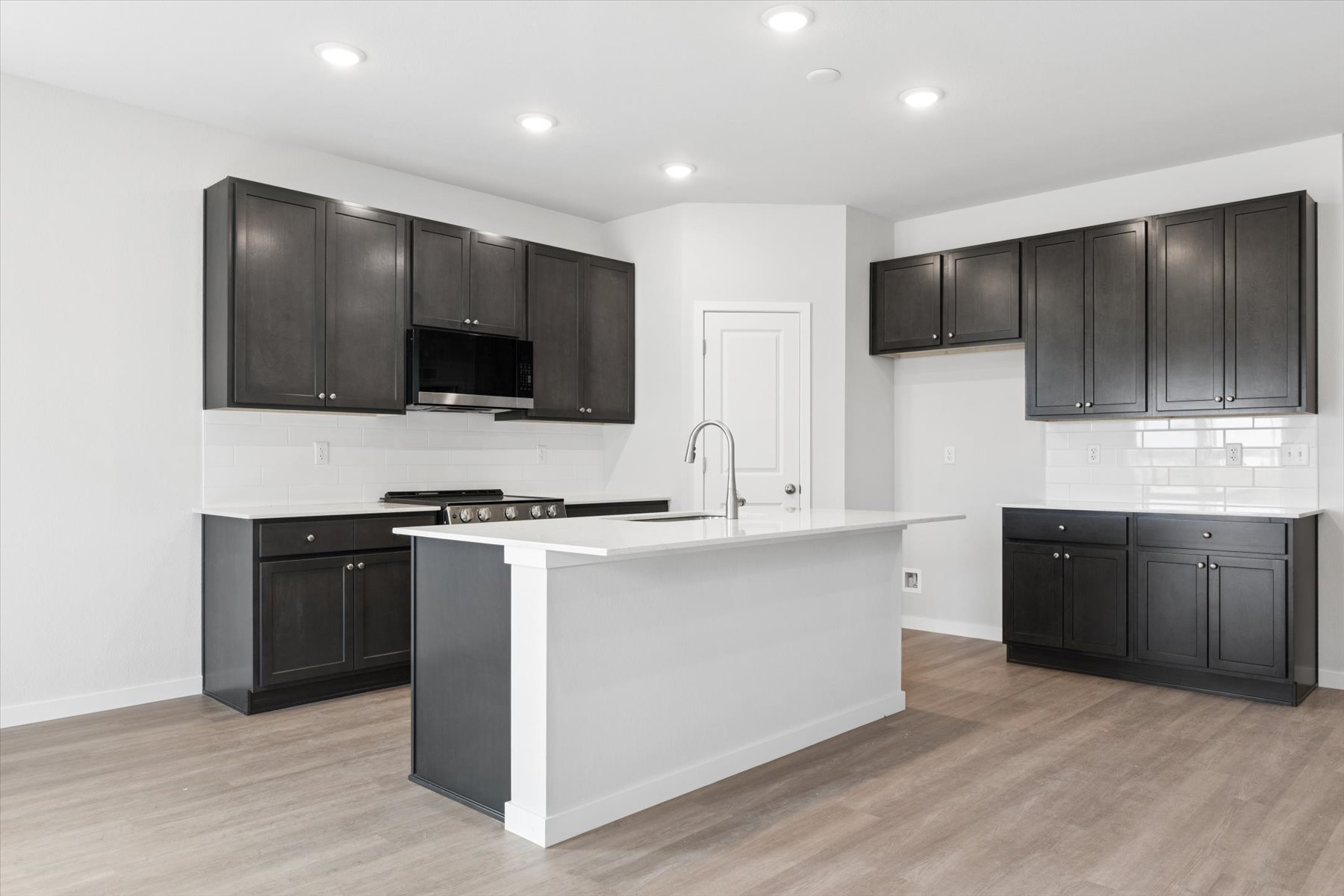 A kitchen with black cabinets.