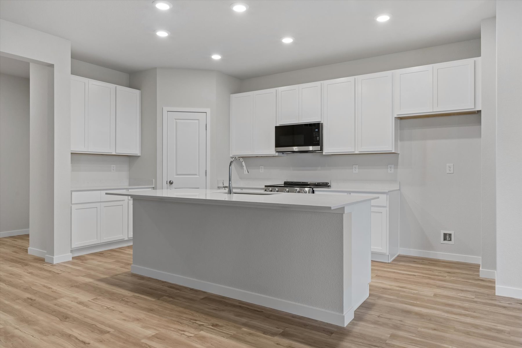 A kitchen with white cabinets.