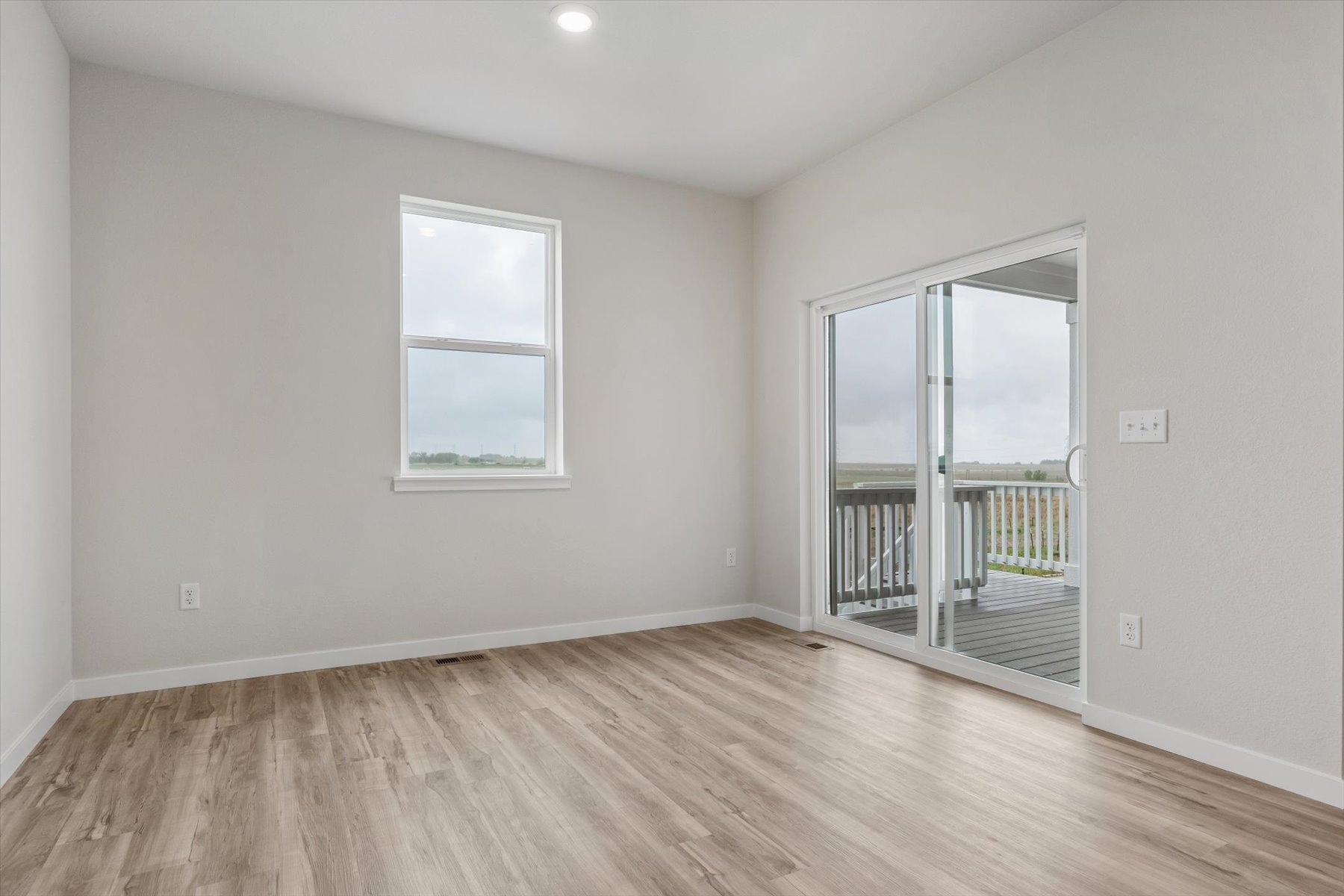 A room with a wood floor and a glass door.