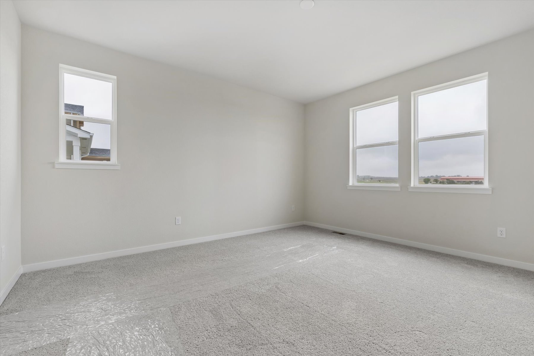 A room with a white wall and windows.