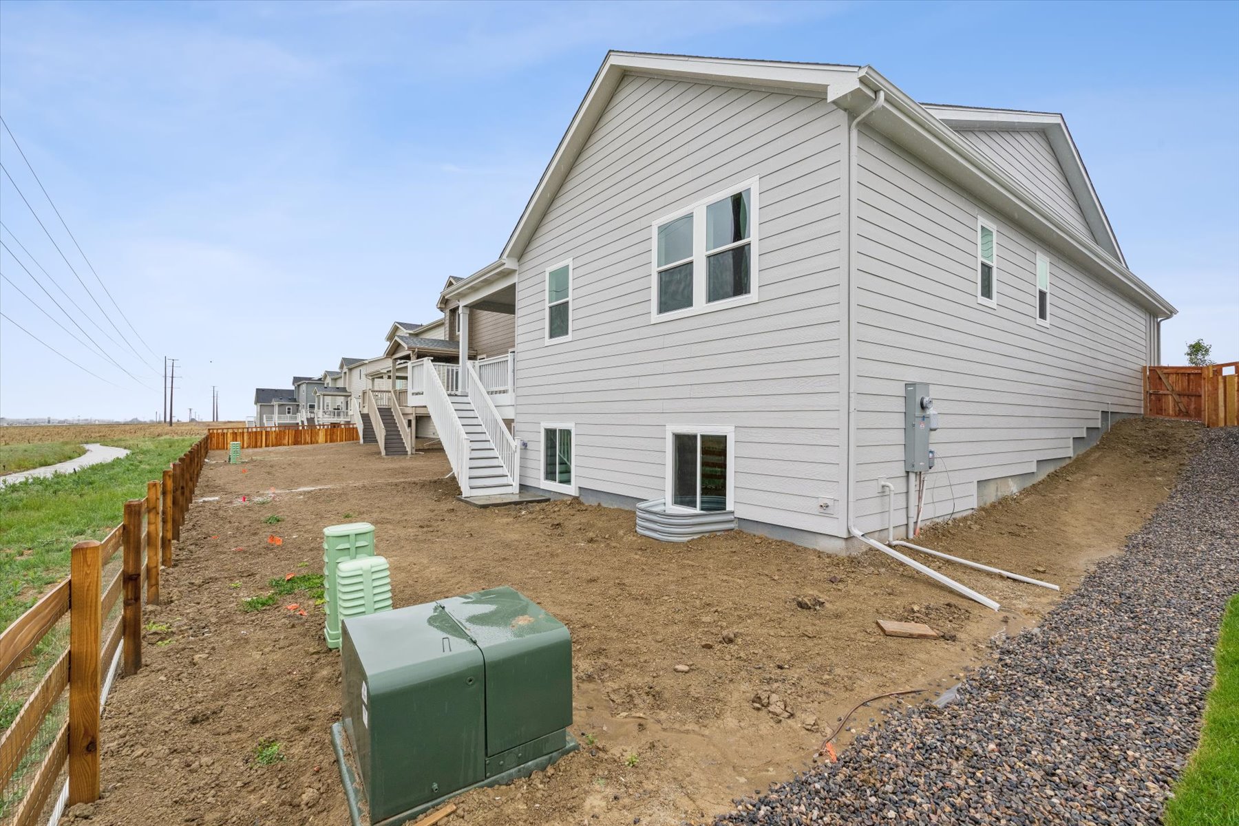 A house with a fence and dirt yard.