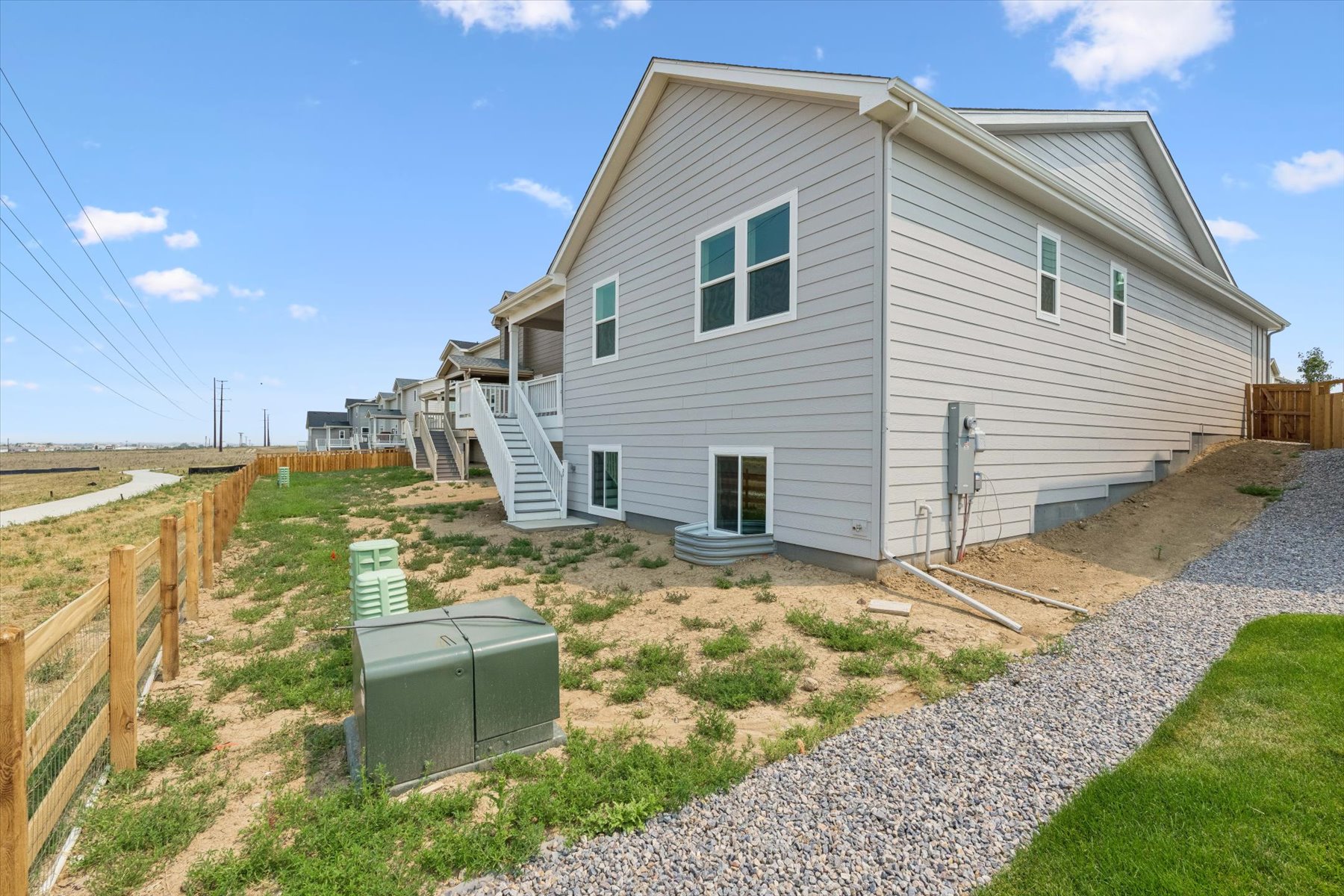 A house with a fence and a gravel driveway.