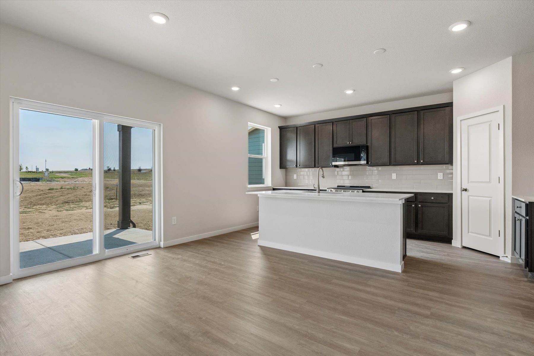 A large kitchen with a large glass door.