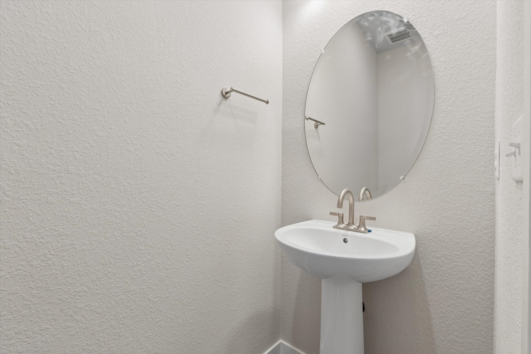 A bathroom with a round mirror.