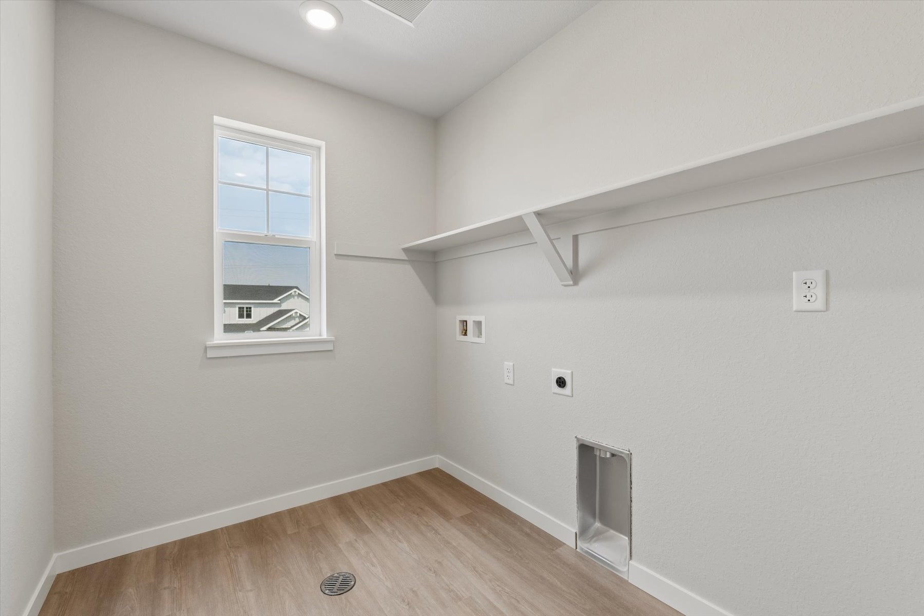 A room with a wood floor and a window.